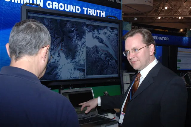 Hampton, Va. (April 3, 2006) - Mark Drajeske explains to Herman Hill the Common Ground Truth Server which displays a consistent representation of the ground, to aid in tactical decision making in the battlefield, during the 2006 U.S. Joint Forces Command (USJFCOM) Industry Symposium, held at the Ham. Decision skills guide: five roles, and why reversibility sets the process